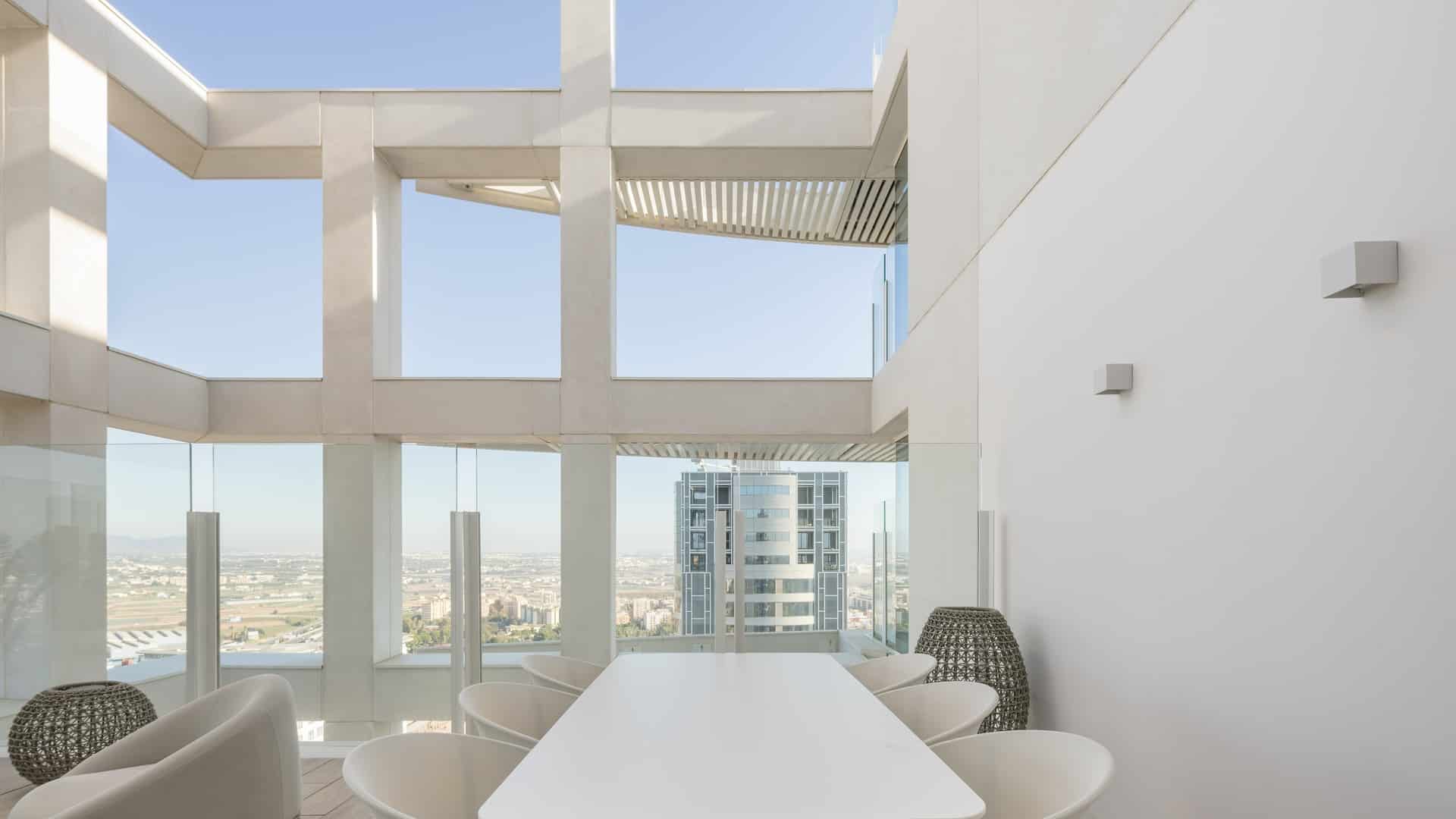 Terraza acristalada con vistas a Valencia y apliques VERSALLES de JISO en pared, ático Edificio Ikon